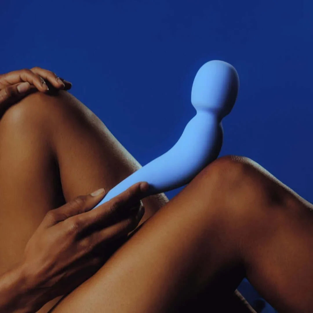 woman holding vibrating wand sex toy against her body