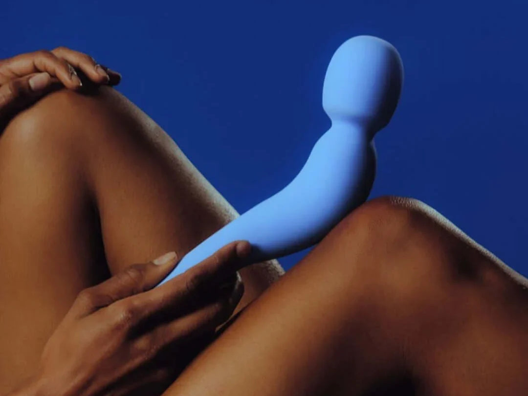 woman holding vibrating wand sex toy against her body
