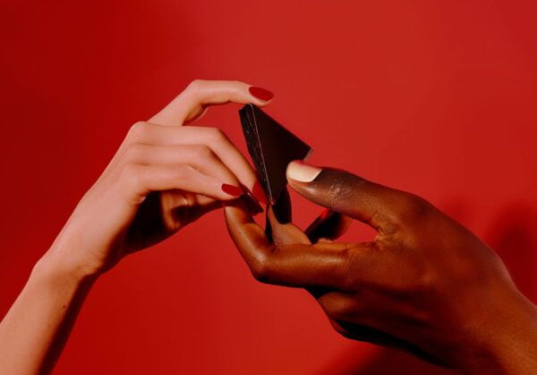 A man and woman share a square of aphrodisiac chocolate